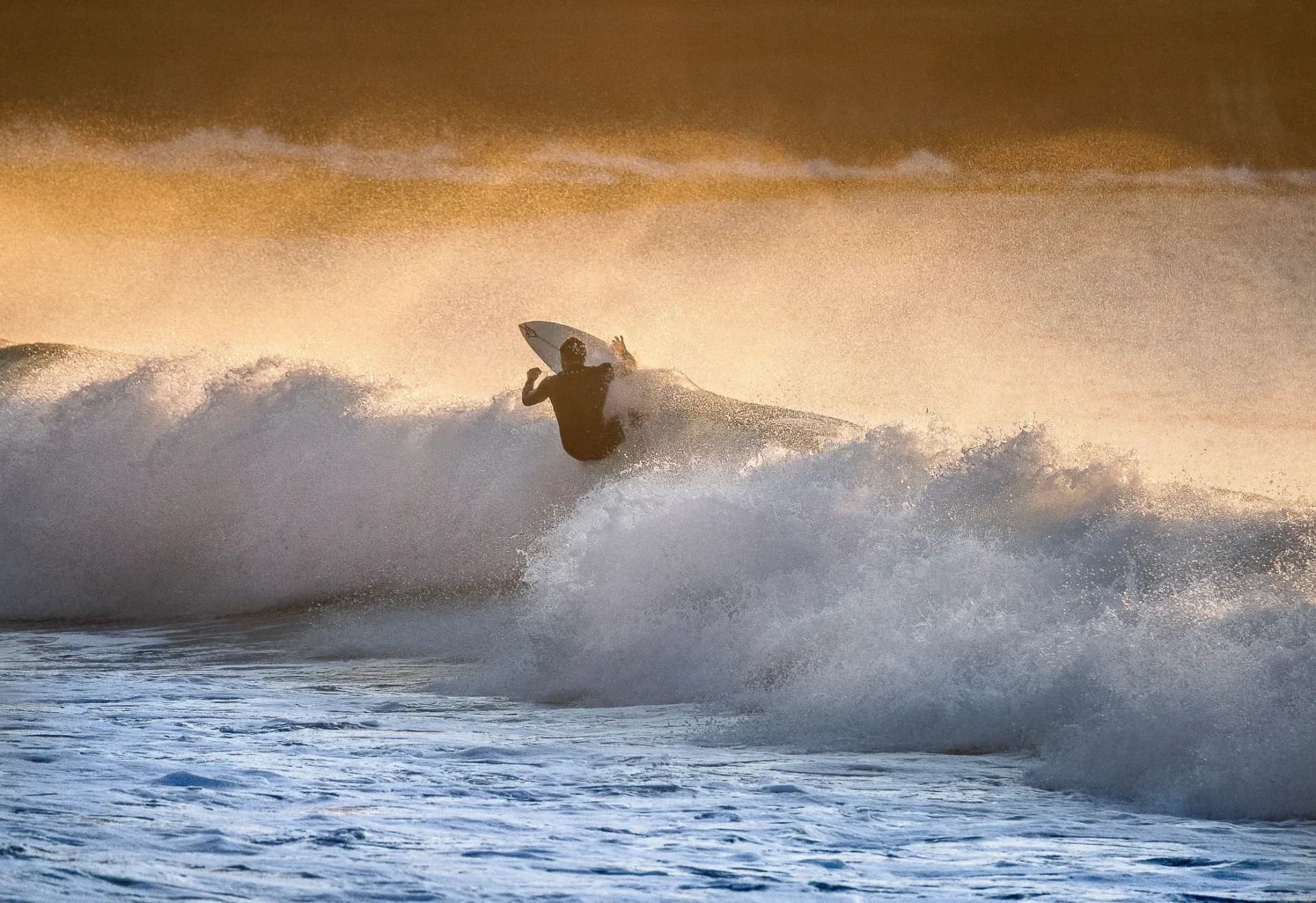 a-surfer-on-a-wave-at-dawn-with-golden-light-shiny-2024-10-18-04-38-28-utc.jpg